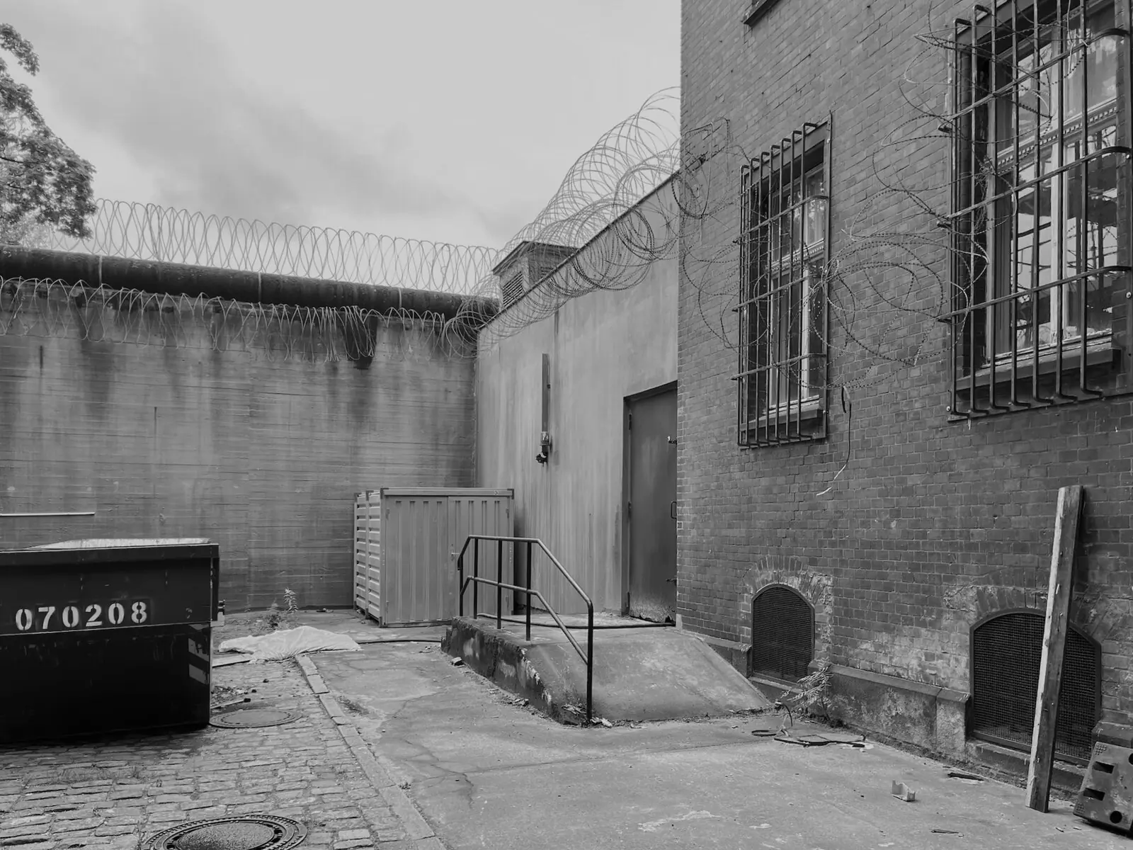 Gefängnishof im Bestand mit Mauer und Klinkerbau
